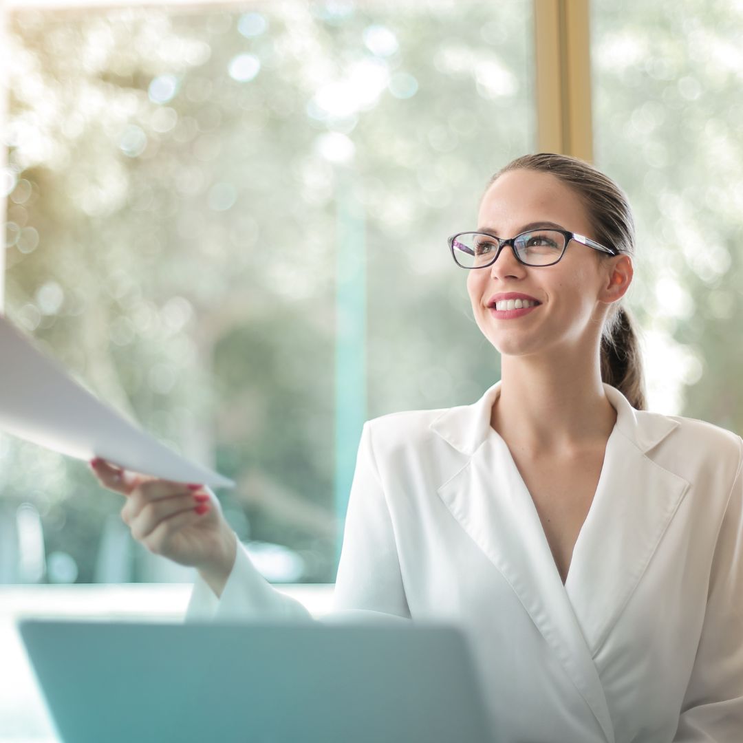 professional woman handing off a sheet of paper