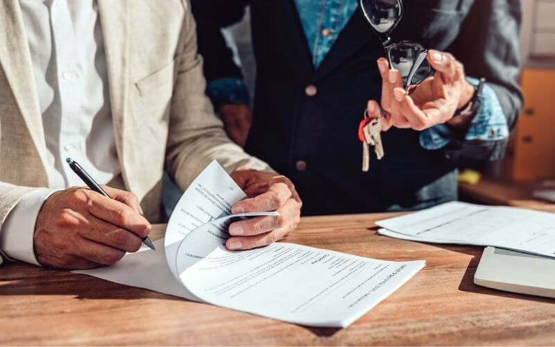 people signing paperwork