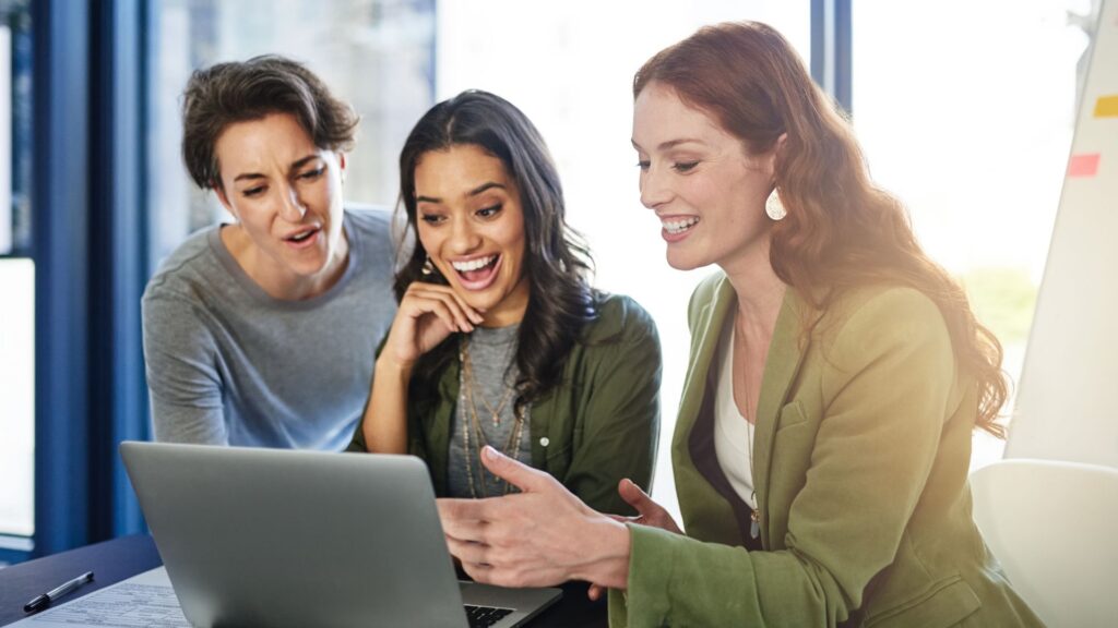 business team smiling at laptop