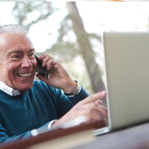 man on phone call looking at laptop